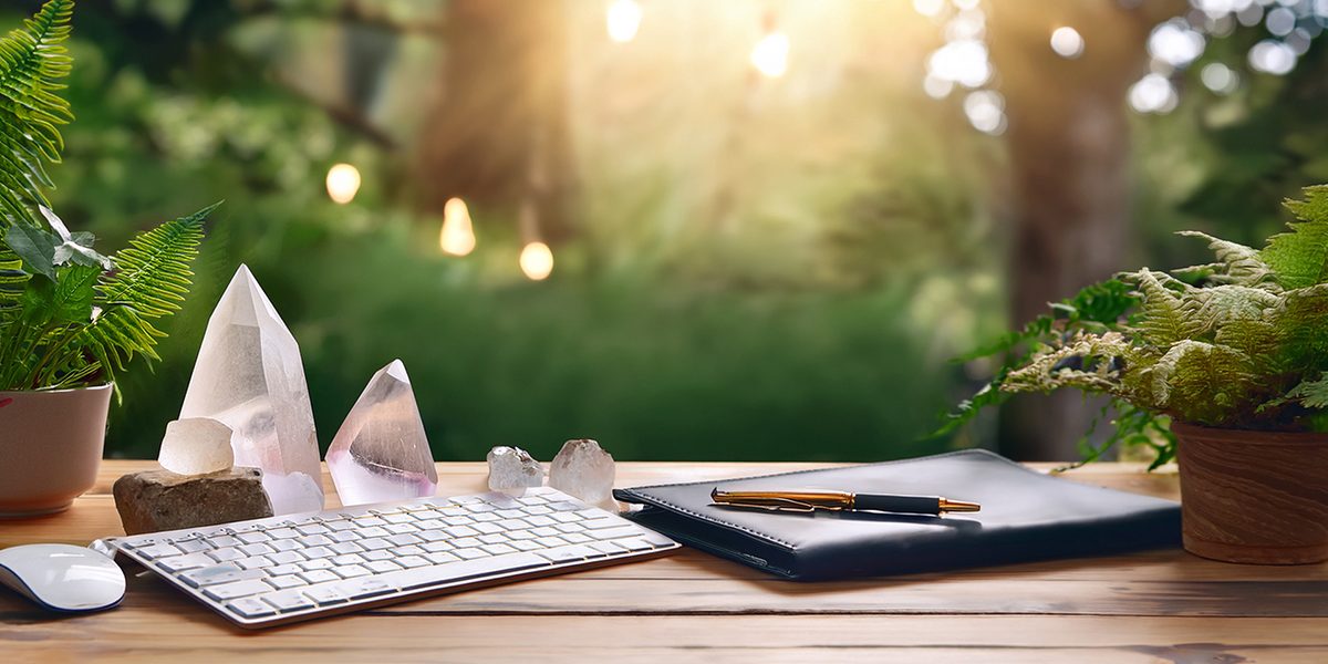 Schreibtisch mit Tastatur, Kristallen, Stift und Naturblick – Symbol für Ebrus Arbeit als Spirituelle Mentorin für Business & Bewusstsein